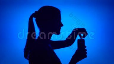 女人在红色背景上打开软饮料罐的剪影。 女`的脸是普通饮料汽水